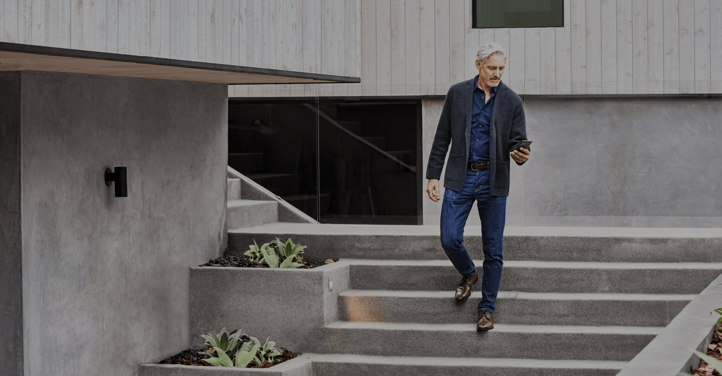 Man checking phone as he walks down stairs savant